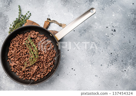 Frying Pan with fried mince beef meat, fresh cooked forcemeat. grey background. top view Frying Pan with fried mince beef meat, fresh cooked forcemeat. grey background. top view 137454324