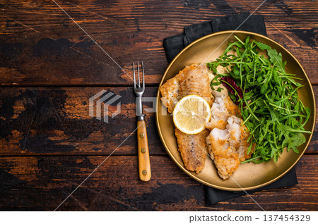 Roasted Pollock fish fillet on a plate with salad. wooden background. top view Roasted Pollock fish fillet on a plate with salad. wooden background. top view 137454329
