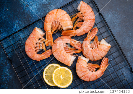 Ready for cooking Headless Red shrimps, raw Prawns on a rack. blue background. top view 137454333