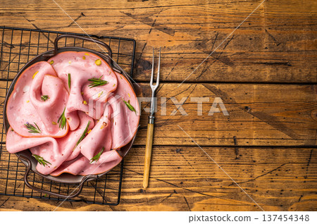 Mortadella sausage slices with pistachios for sandwiches in steel tray. wooden background. top view 137454348
