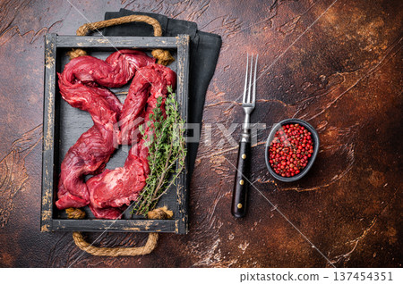 Beef cut Machete Skirt Steak, raw marble meat in wooden tray. black background. top view Beef cut Machete Skirt Steak, raw marble meat in wooden tray. black background. top view 137454351