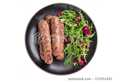Roasted beef and lamb meat kebabs sausages on plate with salad isolated on white background. top view 137454387
