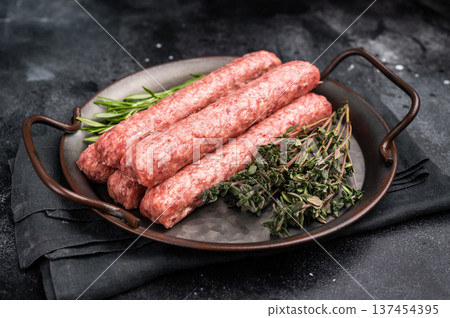 Fresh minced beef and lamb kebabs with fresh spices, arabic kofta kofte kebab. black background. top view Fresh minced beef and lamb kebabs with fresh spices, arabic kofta kofte kebab. black background. top view 137454395