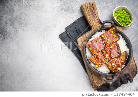 Japanese Cuisine Unadon, grilled unagi eel with rice in a skillet. white background. top view Japanese Cuisine Unadon, grilled unagi eel with rice in a skillet. white background. top view 137454404