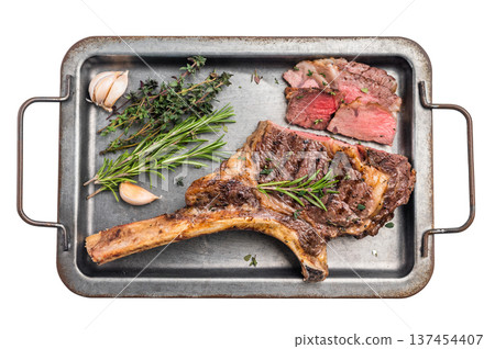 BBQ cooked Tomahawk beef steak, prime ribeye with bone on tray with herbs isolated on white background. top view BBQ cooked Tomahawk beef steak, prime ribeye with bone on tray with herbs isolated on white background. top view 137454407