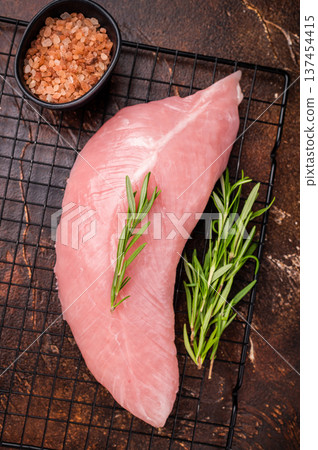 Raw turkey breast fillet, uncooked poultry meat. brown background. top view Raw turkey breast fillet, uncooked poultry meat. brown background. top view 137454415