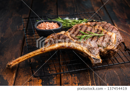 Grilled Tomahawk beef steak, cooked rib eye with bone. wooden background. top view Grilled Tomahawk beef steak, cooked rib eye with bone. wooden background. top view 137454419
