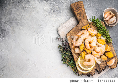 Fresh Seafood cocktail, raw Mix with Mussels, Clams, Prawns, Shrimps and squid on wooden board. white background. top view 137454433