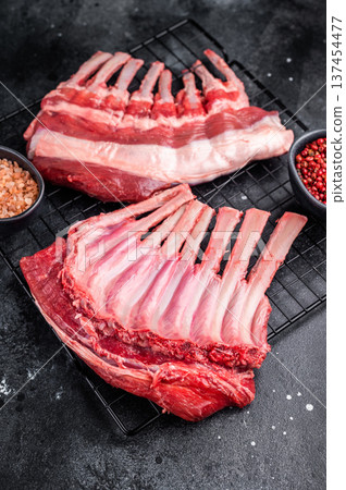 Raw rack of lamb, fresh mutton meat for chops cutlets. black background. top view Raw rack of lamb, fresh mutton meat for chops cutlets. black background. top view 137454477