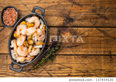 Ready for cooking fresh Raw Seafood Cocktail with Mussels, Clams, Prawns, Shrimps and squid in skillet. wooden background. top view 137454520
