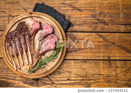 Grilled lamb chops, mutton meat cutlets steaks on wooden board. wooden background. top view Grilled lamb chops, mutton meat cutlets steaks on wooden board. wooden background. top view 137454531