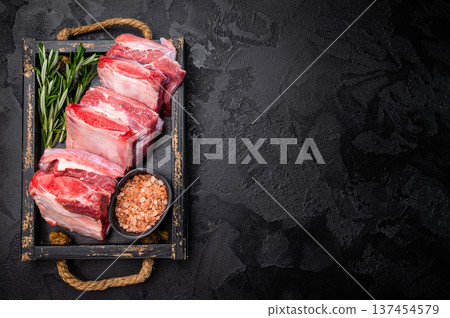 Raw Veal Short Rib, fresh beef meat with bone and herbs for cooking . black background. top view Raw Veal Short Rib, fresh beef meat with bone and herbs for cooking . black background. top view 137454579