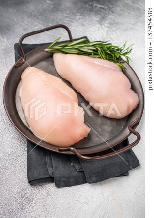 Raw poultry fillets, ready to be seasoned and cooked. These versatile cuts are ideal for grilling, baking, or stir-frying. white background. top view 137454583