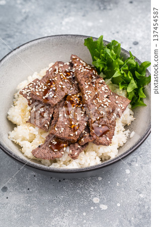 Delectable yakiniku feast, featuring a variety of marbled beef cuts and rice. A culinary journey that captures the essence of Japanese grilling traditions. grey background. top view Delectable yakiniku feast, featuring a variety of marbled beef cuts and rice. A culinary journey that captures the essence of Japanese grilling traditions. grey background. top view 137454587