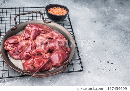Raw poultry liver, chicken offals beautifully displayed, ready for seasoning. A nutritious ingredient ideal for gourmet dishes and traditional recipes. grey background. top view 137454609