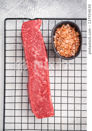 Premium Japanese wagyu beef steak, highlighting its tender texture and luxurious fat content. Ideal for those seeking a truly indulgent culinary experience. grey background. top view Premium Japanese wagyu beef steak, highlighting its tender texture and luxurious fat content. Ideal for those seeking a truly indulgent culinary experience. grey background. top view 137454630