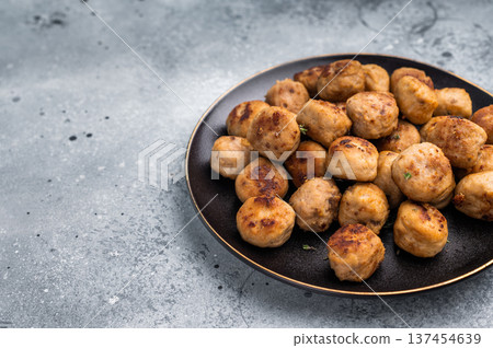 Savory meatballs, meat dumplings garnished with fresh herbs. A delightful addition to any meal, bringing warmth and satisfaction to the table. grey background. top view Savory meatballs, meat dumplings garnished with fresh herbs. A delightful addition to any meal, bringing warmth and satisfaction to the table. grey background. top view 137454639