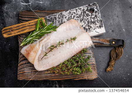 Freshly cut cod fish fillet, highlighting its mild taste and versatility in various dishes. black background. top view 137454654