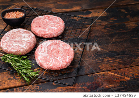 Frozen Meat patties ready for grilling, forcemeat of pork and beef for burgers. wooden background. top view Frozen Meat patties ready for grilling, forcemeat of pork and beef for burgers. wooden background. top view 137454659