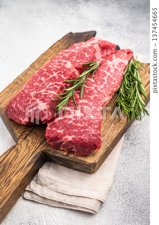 Juicy raw shoulder denver steak, highlighting its tenderness and quality. Perfect for marinating or slow-cooking to enhance its delicious flavor. grey background. top view Juicy raw shoulder denver steak, highlighting its tenderness and quality. Perfect for marinating or slow-cooking to enhance its delicious flavor. grey background. top view 137454665