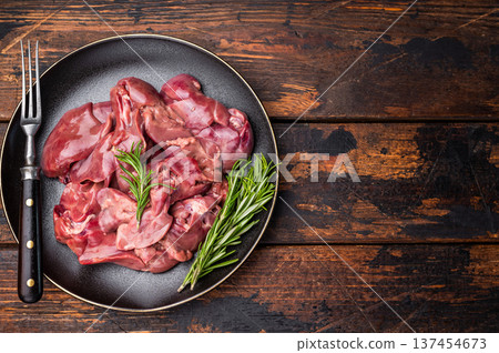 Raw chicken liver, featuring a glossy sheen and rich hue. A versatile ingredient that brings bold flavors to any culinary creation. wooden background. top view Raw chicken liver, featuring a glossy sheen and rich hue. A versatile ingredient that brings bold flavors to any culinary creation. wooden background. top view 137454673