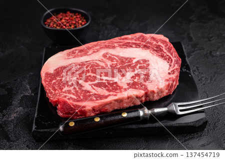 Fresh raw ribeye beef steak, marbled rib fillet cut, premium red meat for grilling roasting or steakhouse cooking on dark background 137454719