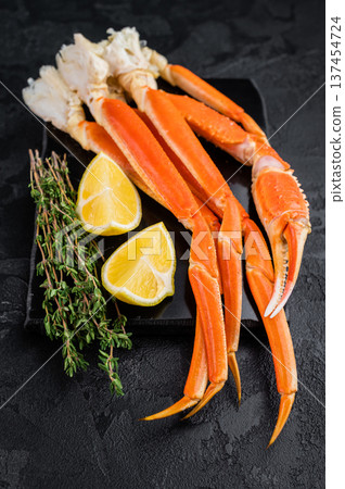 Gourmet kamchatka crab legs with lemon and thyme on dark slate background high quality seafood copy space Gourmet kamchatka crab legs with lemon and thyme on dark slate background high quality seafood copy space 137454724