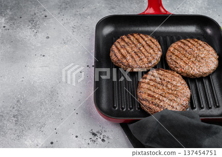 Cooked mixed meat patties made from beef and lamb in grill pan. Light stone background with copy space for food design. Cooked mixed meat patties made from beef and lamb in grill pan. Light stone background with copy space for food design. 137454751