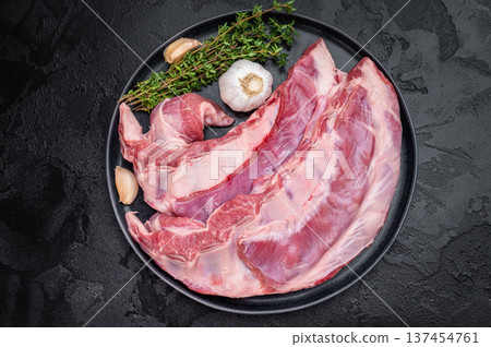 Fresh raw lamb meat belly or breast with herbs and garlic on dark background uncooked ingredient for roasting bbq and slow cooking Fresh raw lamb meat belly or breast with herbs and garlic on dark background uncooked ingredient for roasting bbq and slow cooking 137454761