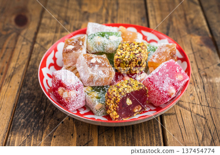 Mixed lokum candy cubesin eastern plate on wooden background. Handmade confectionery with modern rustic style. Mixed lokum candy cubesin eastern plate on wooden background. Handmade confectionery with modern rustic style. 137454774