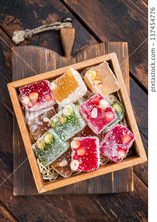 Mixed lokum candy cubes on wooden background. Handmade eastern confectionery with modern rustic style. Mixed lokum candy cubes on wooden background. Handmade eastern confectionery with modern rustic style. 137454776