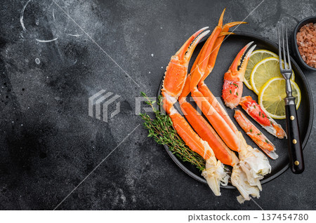 Luxury kamchatka crab legs with lemon slices and fresh herbs on dark plate gourmet seafood on textured black background Luxury kamchatka crab legs with lemon slices and fresh herbs on dark plate gourmet seafood on textured black background 137454780
