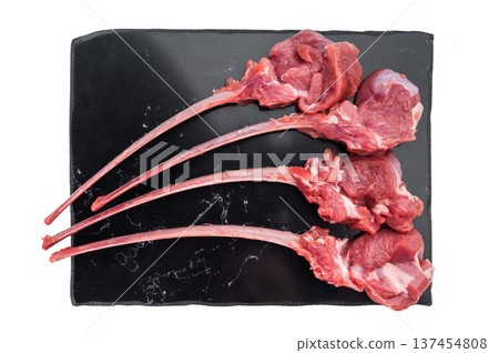 Raw lamb cutlets on bone on black stone board isolated background top view butcher meat with copy space. Raw lamb cutlets on bone on black stone board isolated background top view butcher meat with copy space. 137454808