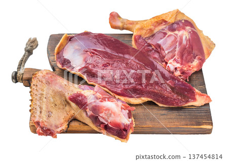 Raw duck meat cuts with breast and leg on wooden board isolated on white background top view. Gamebird poultry game meat assortment. 137454814