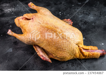 Wild duck game carcass from hunting on dark studio background. Fresh raw poultry meat for cooking rustic and seasonal cuisine. Wild duck game carcass from hunting on dark studio background. Fresh raw poultry meat for cooking rustic and seasonal cuisine. 137454867