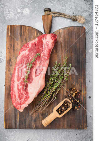 Raw beef chuck eye steak with rich marbling on wooden board with thyme and pepper. Fresh beef cut overhead with copy space. Raw beef chuck eye steak with rich marbling on wooden board with thyme and pepper. Fresh beef cut overhead with copy space. 137454873