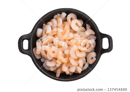 Small peeled shrimp in cast iron pan on isolated background , seafood ingredient background with copy space for recipes and menu design. Small peeled shrimp in cast iron pan on isolated background , seafood ingredient background with copy space for recipes and menu design. 137454899