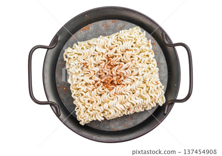 Raw wheat instant noodle brick seasoned with paprika served with cilantro in pan on wooden table Asian convenience food Raw wheat instant noodle brick seasoned with paprika served with cilantro in pan on wooden table Asian convenience food 137454908