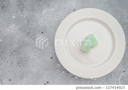 Dishwasher detergent tablets placed on white plate over gray stone background minimal cleaning concept with strong copy space Dishwasher detergent tablets placed on white plate over gray stone background minimal cleaning concept with strong copy space 137454923