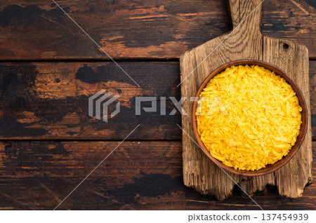 Bowl of shredded cheddar cheese on rustic wooden board with dark wood background copy space for cooking and recipe concepts 137454939