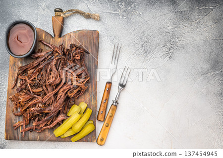 Barbecue pulled beef brisket with smoky texture, served with gherkins and dip, slow cooked beef for BBQ menu or grill concept. 137454945