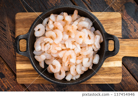 Cooked mini prawns in rustic skillet, salad shrimp portion on wooden surface, healthy protein seafood for catering and restaurant concept.. 137454946