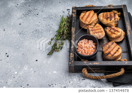 Tender char grilled pork medallion steak, perfect for adding a touch of elegance to your dinner plate.grey background. top view 137454978