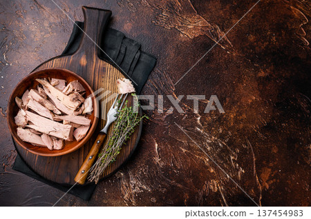 Sustainable tinned tuna fillet in a wooden bowl, promoting eco friendly eating without sacrificing taste. brown background. top view 137454983
