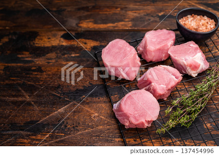Uncooked pork loin medallion, cut tenderloin ready to be seasoned and cooked into a delicious gourmet dish. wooden background. top view Uncooked pork loin medallion, cut tenderloin ready to be seasoned and cooked into a delicious gourmet dish. wooden background. top view 137454996