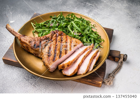 Mouthwatering grilled pork chop with a stunning presentation, perfect for serving at special occasions. grey background. top view Mouthwatering grilled pork chop with a stunning presentation, perfect for serving at special occasions. grey background. top view 137455040