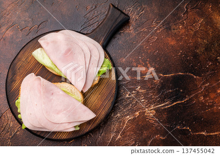 Colorful ham sandwich bursting with flavor and freshness, perfect for lunchboxes or casual dining. brown background. top view Colorful ham sandwich bursting with flavor and freshness, perfect for lunchboxes or casual dining. brown background. top view 137455042