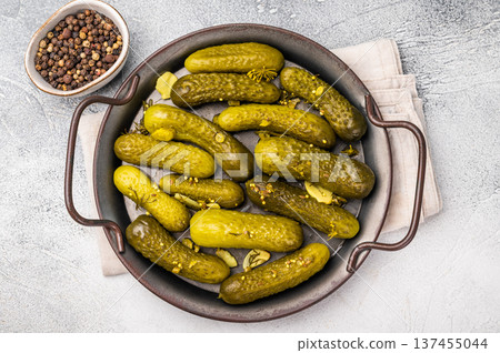 Freshly jarred dill pickles, a delightful addition to any meal or charcuterie board that adds a zesty crunch. grey background. top view 137455044