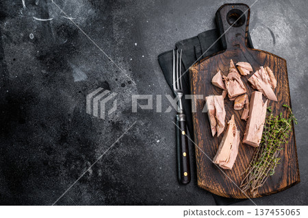 Chunky tinned tuna served on a wooden board, perfect for meal prep or easy weeknight dinners. black background. top view 137455065