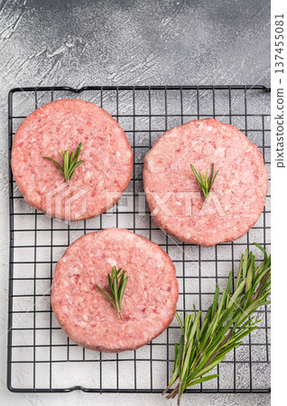 Close up of a juicy raw meat patty cutlet, ideal for crafting mouthwatering sandwiches and savory dishes. white background. top view 137455081